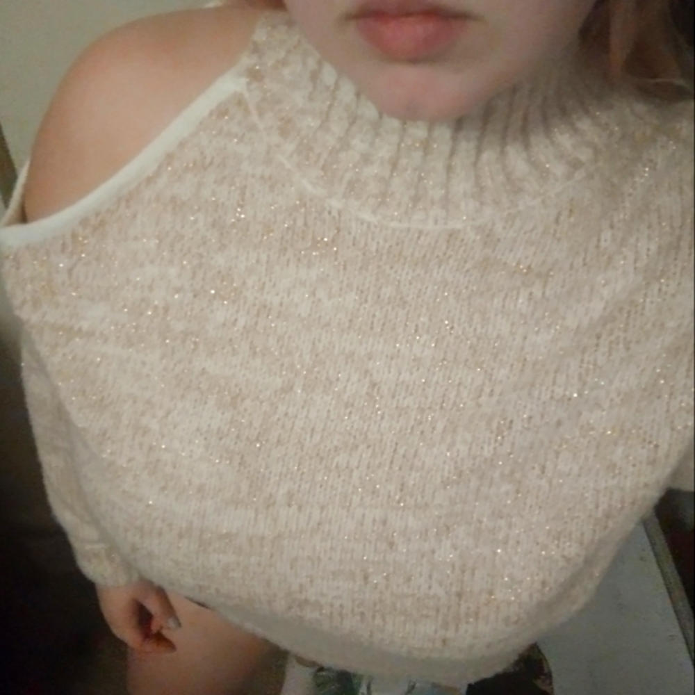 Glittery sweater with cutout shoulder.
